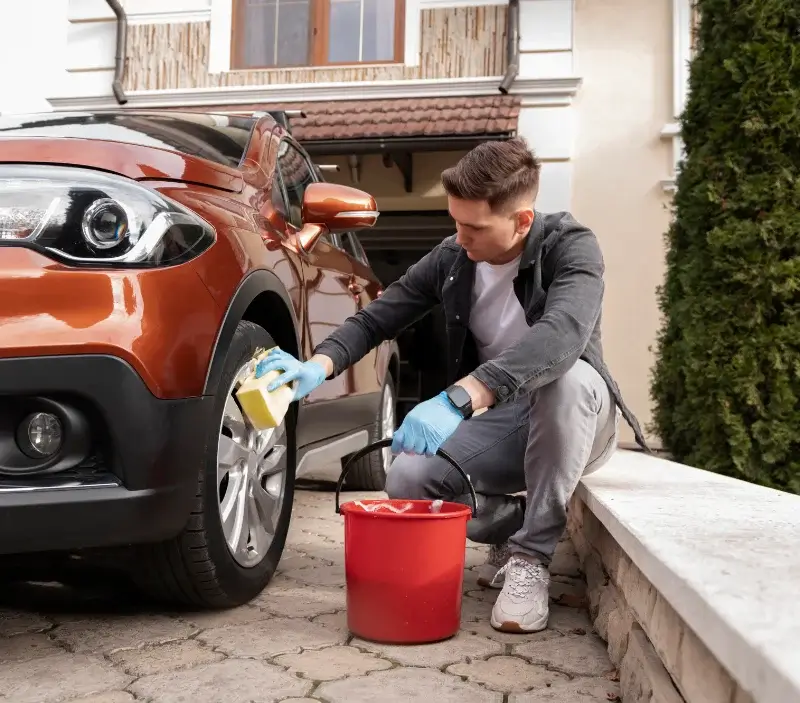 Lavage auto à domicile Courtonne-les-Deux-Églises : professionnel intervenant sur un véhicule